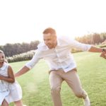 a father running through field with son and daughter next to him and his wife running behind them