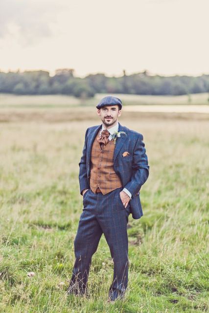 a vintage groom's look with a navy pritned suit, a brown waistcoat, a tie and a grey cap