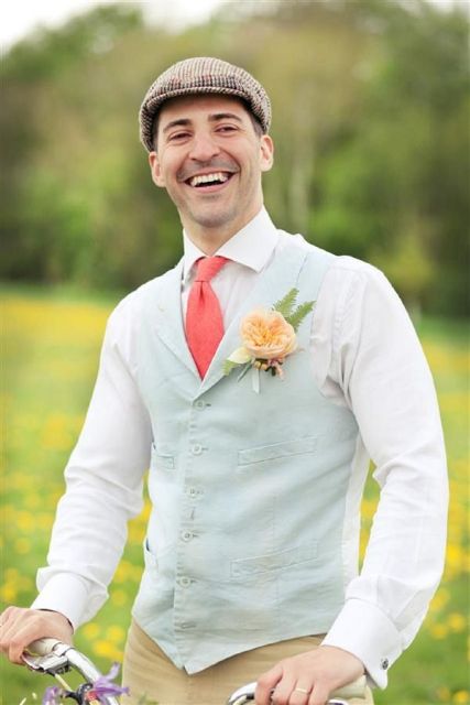 a bright vintage-inspired groom's outfit with tan pants, a white shirt, a mint green waistcoat, a printed cap