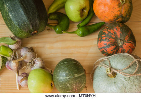 Harvest or Thanksgiving background with autumnal fruits and gourds on a rustic wooden table - Stock Image