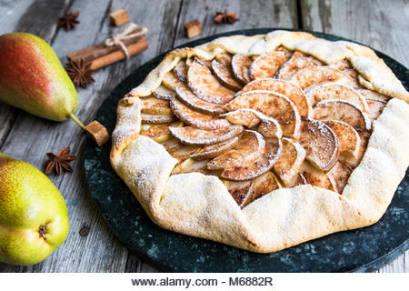 Pie with apples, pears and cinnamon on an old wooden background. Apple tart - Stock Image