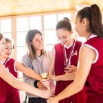 basketball players huddled up and receiving a trophy award