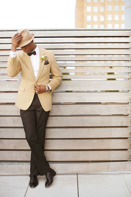 an elegant groom's outfit with black pants, a white shirt, a buttermilk jacket, a matching hat