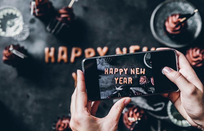 Woman photographing flat lay new year cookies
