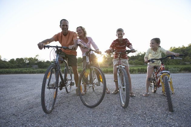Family with daughter (7-9) and son (11-13) riding bicycles, low angle view