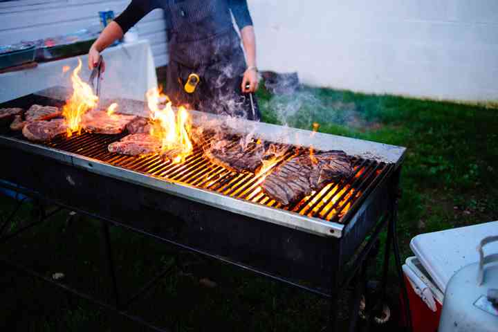 outdoor reception steaks being cooked on grill