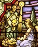 Stained glass window showing Mary with the infant Jesus and her husband Joseph with a bright star above them