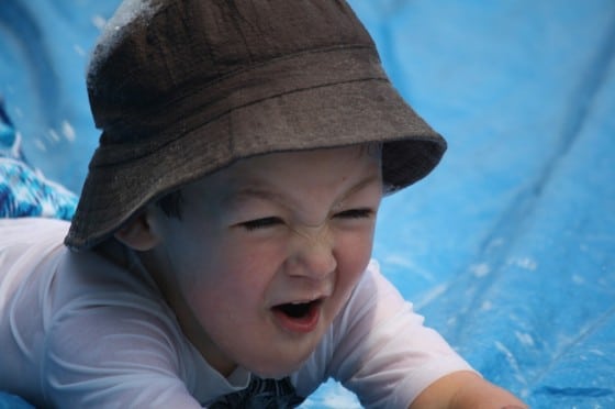 close up 3 year old sliding on tarp