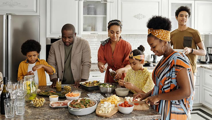 A family stands around a kitchen table