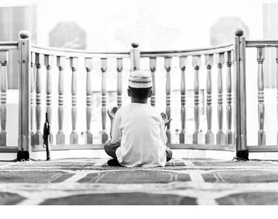 boy prays in the mosque during the month of Ramadan - Stock Image
