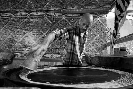 Alexandria, Egypt February 6, 2021 Konafa maker and seller during the holy month of Ramadan which is an Arabic traditional desert - Stock Image