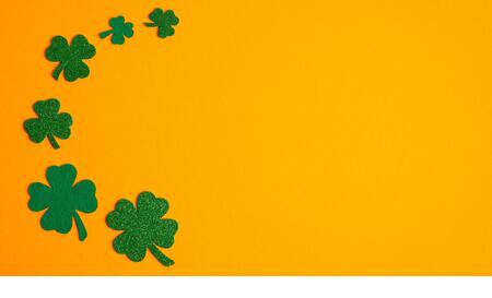 Frame border of shamrock four leaf clovers on orange background. Happy Saint Patrick s day concept. Greeting card, party invitation template, banner m - Stock Image