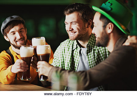 Happy men spending St. Patrick day in tavern - Stock Image