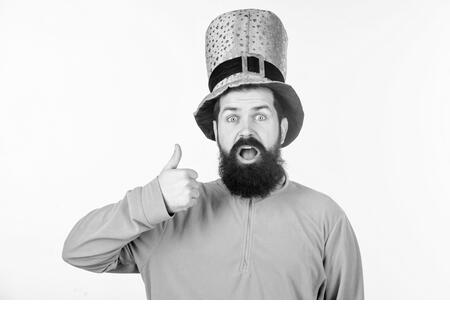 Happy saint patricks day. Hipster in leprechaun hat and costume keeping mouth open. Bearded man celebrating saint patricks day. Irish man with beard wearing green. Thumbs up for saint patrick. - Stock Image