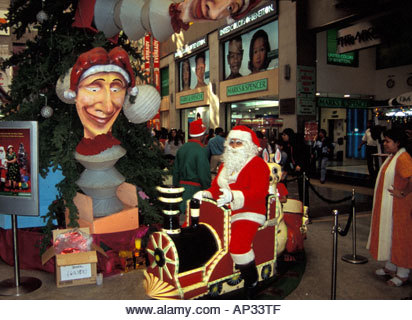 Indian Santa Claus on toy train in shopping centre at Christmas, Mumbai, South India - Stock Image