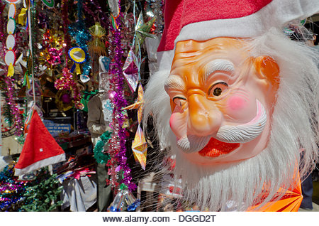 Christmas decorations like Santa Claus masks for sale at the local market in Mysore, India, Asia - Stock Image