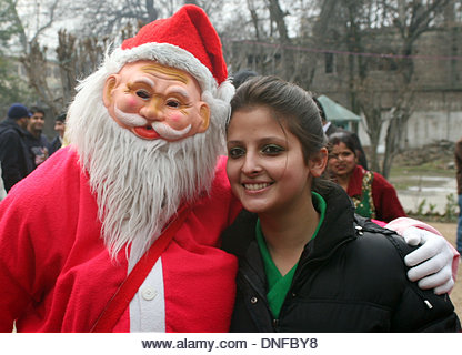 Srinagar, Indian Administered Kashmir 25 December2013. Santa Claus poses with a girls inside the Holy Family Catholic Church during Christmas in Srinagar, the summer capital of Indian- administered Kashmir. he disputed Himalayan region of Kashmir has a minuscule population of Christians, hundreds of whom join mass at the Holy Family Catholic church on Christmas and pray for peace and prosperity of the region. (Sofi Suhail/ Alamy Live News) - Stock Image