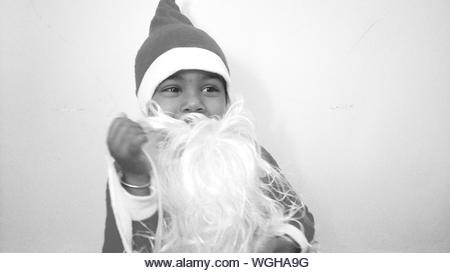 Boy Wearing Santa Claus Costume Against White Background - Stock Image