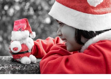 a cute Indian girl child playing with santa claus - Stock Image