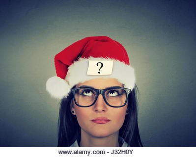 Young woman in santa claus hat with question mark - Stock Image