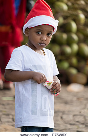 Boy eating ice-cream, wearing a Santa Claus hat, Kochi or Cochin, Kerala, India - Stock Image