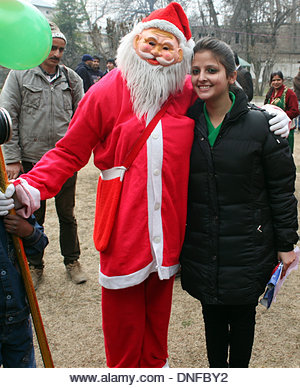 Srinagar, Indian Administered Kashmir 25 December2013. Santa Claus poses with a girls inside the Holy Family Catholic Church during Christmas in Srinagar, the summer capital of Indian- administered Kashmir. he disputed Himalayan region of Kashmir has a minuscule population of Christians, hundreds of whom join mass at the Holy Family Catholic church on Christmas and pray for peace and prosperity of the region. (Sofi Suhail/ Alamy Live News) - Stock Image