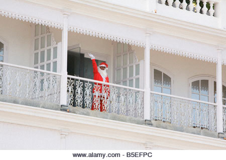 person in a Santa Clause costume waving from a balcony in Pondicherry - Stock Image