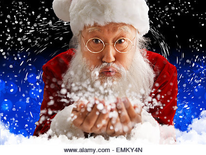 Santa Claus holding snow blowing - Stock Image