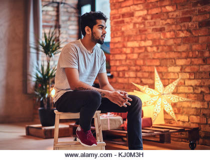 Indian male in the loft room. - Stock Image