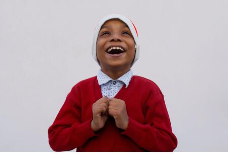 Young boy smiling and wearing Santa Claus hat, during christmas - Stock Image