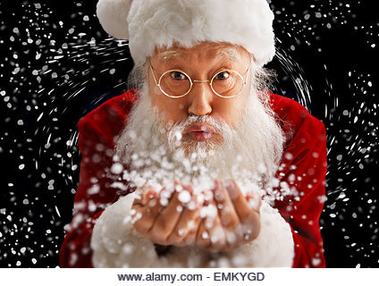 Santa Claus holding snow blowing - Stock Image