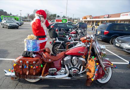 Pennsylvania, USA. 21st Dec, 2021. Matt Johnson of Langhorne, puts on his helmet while dressed as Santa for the ride on his Indian Motorcycle along with other members of the Delaware Valley Iron Indian Riders Association who held their annual Ride Of the Santas and dropped off toys to children at  Saturday, December 21, 2021 at St Francis-St Vincent Home For Children in Bensalem, Pennsylvania. Credit: William Thomas Cain/Alamy Live News - Stock Image