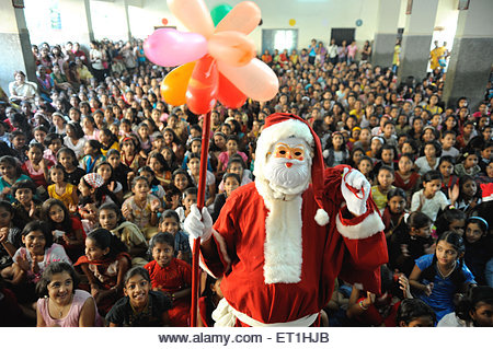 Santa claus coming around children ; Bombay Mumbai ; Maharashtra ; India NO MR - Stock Image