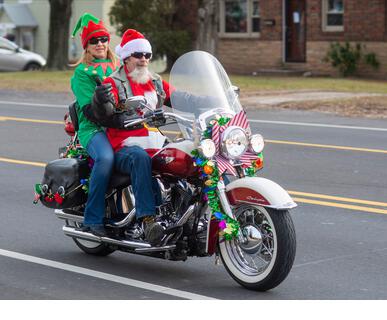 Pennsylvania, USA. 21st Dec, 2021. Debbie Kaelin of Bensalem, rides on the back of a Harley Davidson with Gary Gifford of Bensalem, dressed as Santa, along with other members of the Delaware Valley Iron Indian Riders Association who held their annual Ride Of the Santas and dropped off toys to children at  Saturday, December 21, 2021 at St Francis-St Vincent Home For Children in Bensalem, Pennsylvania. Credit: William Thomas Cain/Alamy Live News - Stock Image