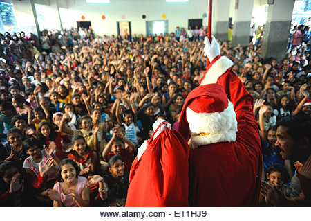 Santa claus coming around children ; Bombay Mumbai ; Maharashtra ; India NO MR - Stock Image