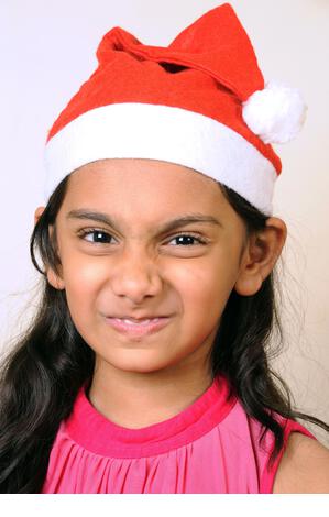 Mumbai, Maharashtra, India- Asia, Dec. 29, 2014 - Happy Indian little cute girl wearing red Santa Claus Hat Celebrating Christmas festival. - Stock Image