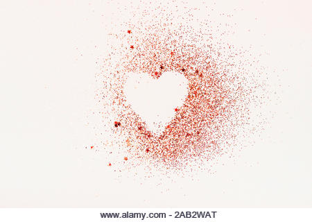 Heart shape made of red glitter and stars on a white background. Valentines day, minimal love concept. - Stock Image