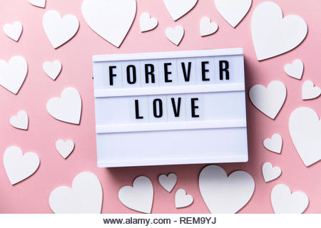 Forever Love lightbox message with white hearts on a pink background - Stock Image