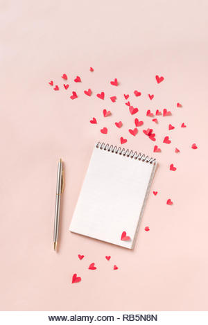 Notebook and red hearts isolated on beige background, copy space. Minimal flat lay with planning for Valentine day, love and romance concept, top view - Stock Image