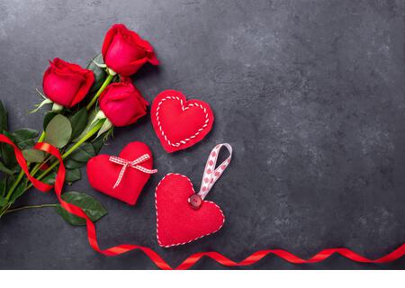 Valentines day greeting card. Red roses and textile hearts on stone background. Top view - Image - Stock Image