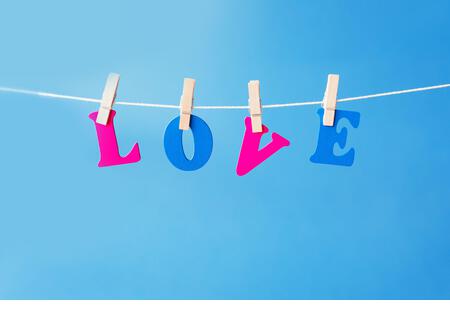 Clothes pegs and I LOVE YOU words on papers on rope on white background Valentines day concept - Stock Image