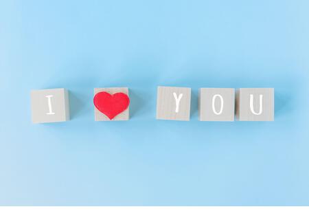 I love you wooden cubes with red heart shape decoration on blue table background and copy space for text. Love, Romantic and Happy Valentines day holiday concept - Stock Image