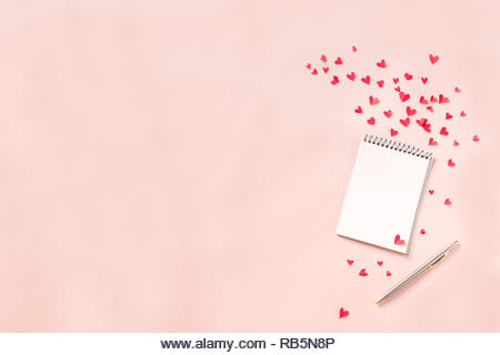 Notebook and red hearts isolated on beige background, copy space. Minimal flat lay with planning for Valentine day, love and romance concept, top view - Stock Image