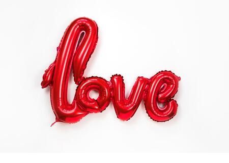 Red golden word LOVE made of inflatable balloons isolated on white background. Red foil balloon letters, concept of romance, Valentine's Day, Mothers - Stock Image