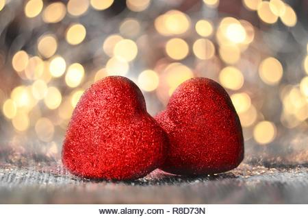 The red Heart shapes on abstract light glitter background in love concept for valentines day - Stock Image