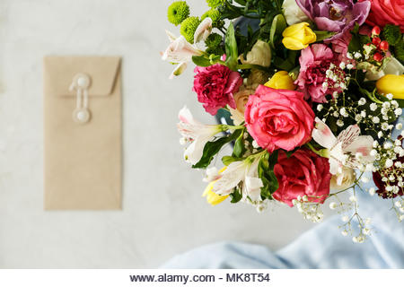 Close-up of bouquet of red roses, yellow tulips and white flowers on blurred background with copy space. Valentine's day concept - Stock Image