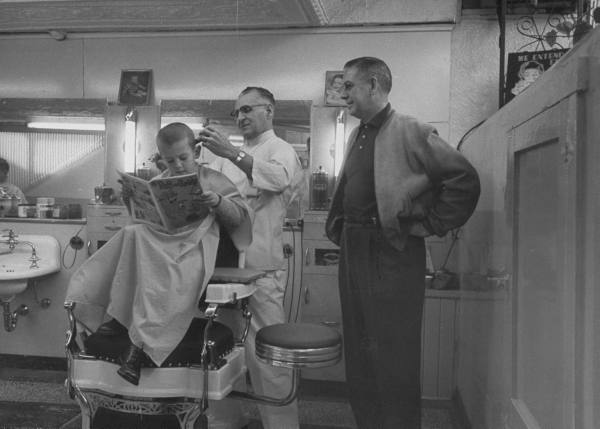 Vintage father and son in the barbershop.