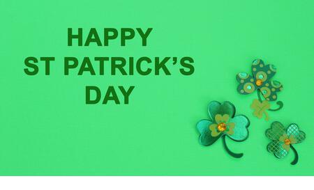 three clovers on a green background with happy st Patricks day message - Stock Image
