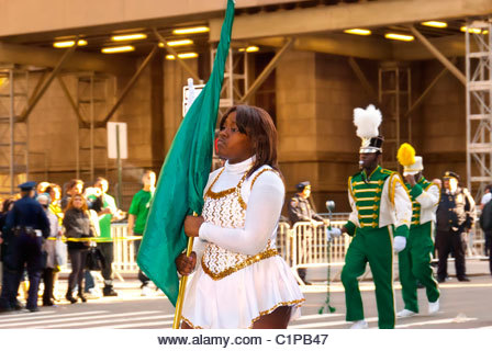 MARCH 17, 2011 - MANHATTAN: St. Patrick's Day Parade green flag girl marching in high school band, St. Patrick's - Stock Image