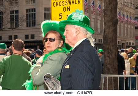 MARCH 17, 2011 - NYC: Couple watching St. Patrick's Day Parade in Fifth Avenue crowd, gentleman and lady wearing - Stock Image